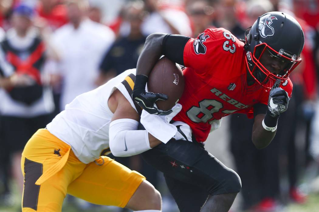 UNLV wide receiver Devonte Boyd (83) is tackled by Wyoming defensive back Marcus Epps (6) durin ...