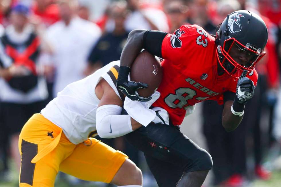 UNLV wide receiver Devonte Boyd (83) is tackled by Wyoming defensive back Marcus Epps (6) durin ...