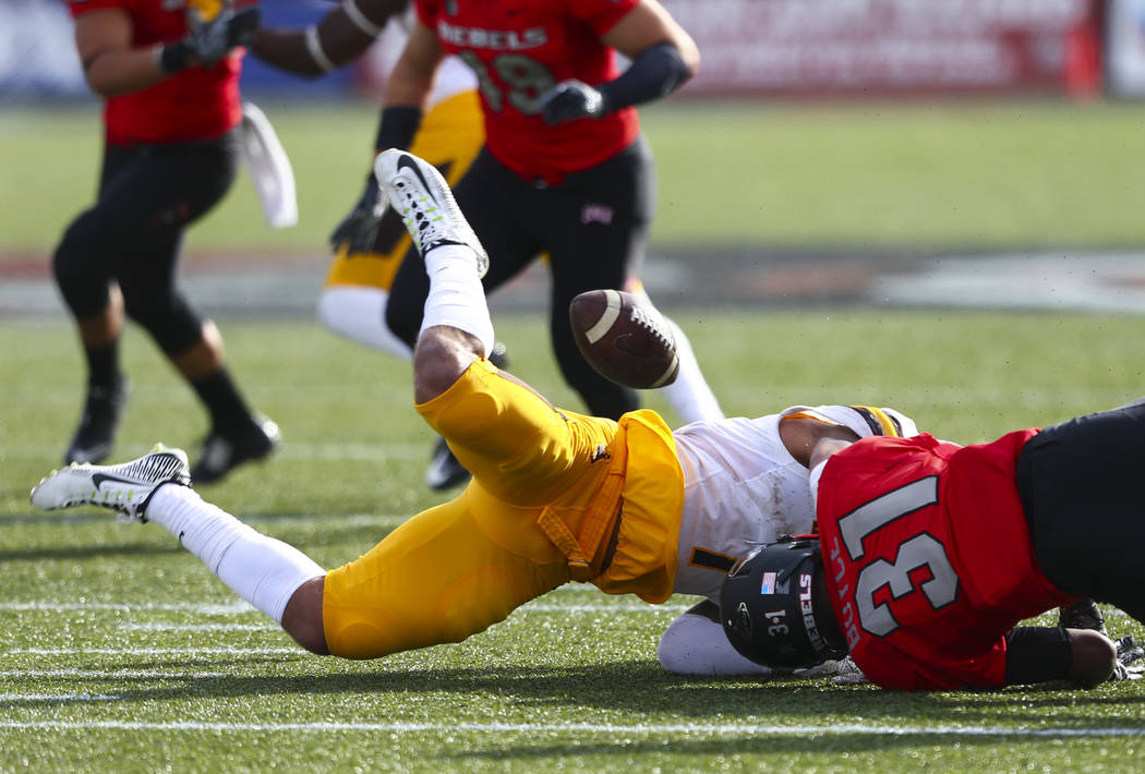 Wyoming linebacker D.J. May (7) fumbles the ball as UNLV defensive back Salah Boyce (31) makes ...