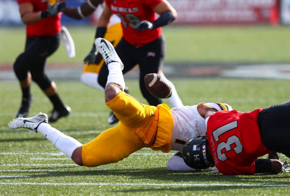 Wyoming linebacker D.J. May (7) fumbles the ball as UNLV defensive back Salah Boyce (31) makes ...