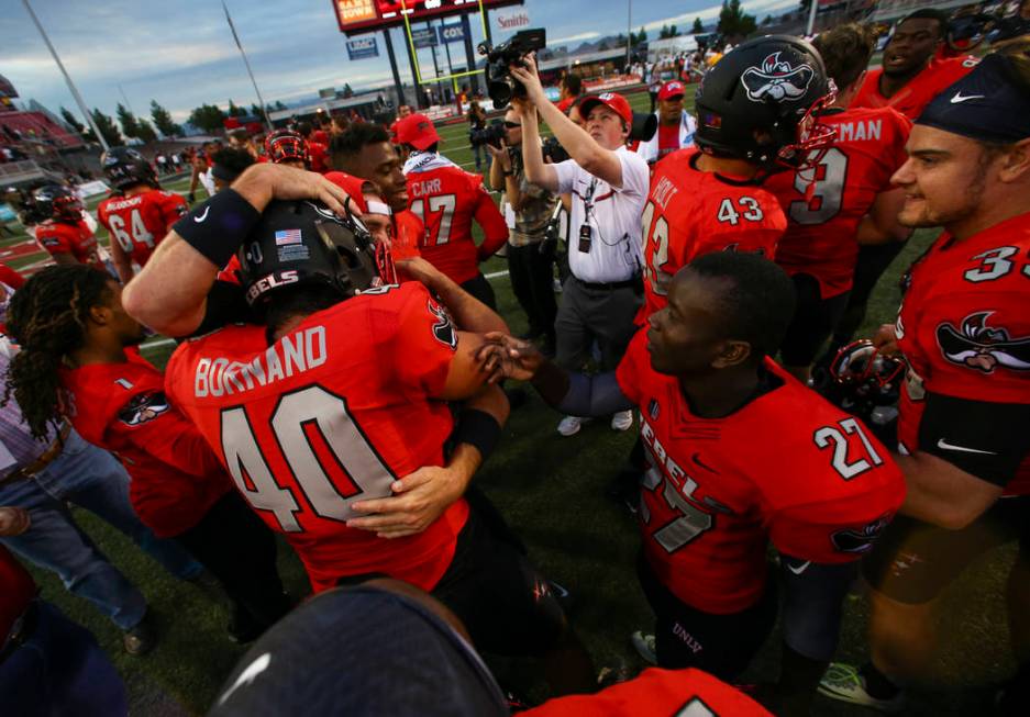 UNLV players celebrate after defeating Wyoming 69-66 in a triple overtime football game at Sam ...