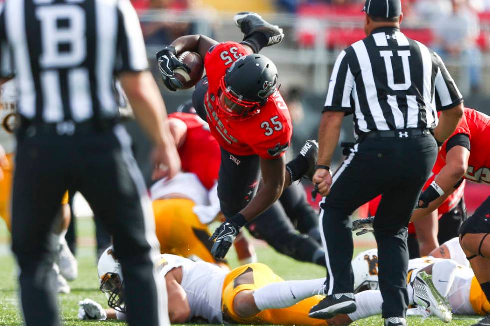 UNLV running back Xzaviar Campbell (35) is tripped up during a football game against Wyoming at ...