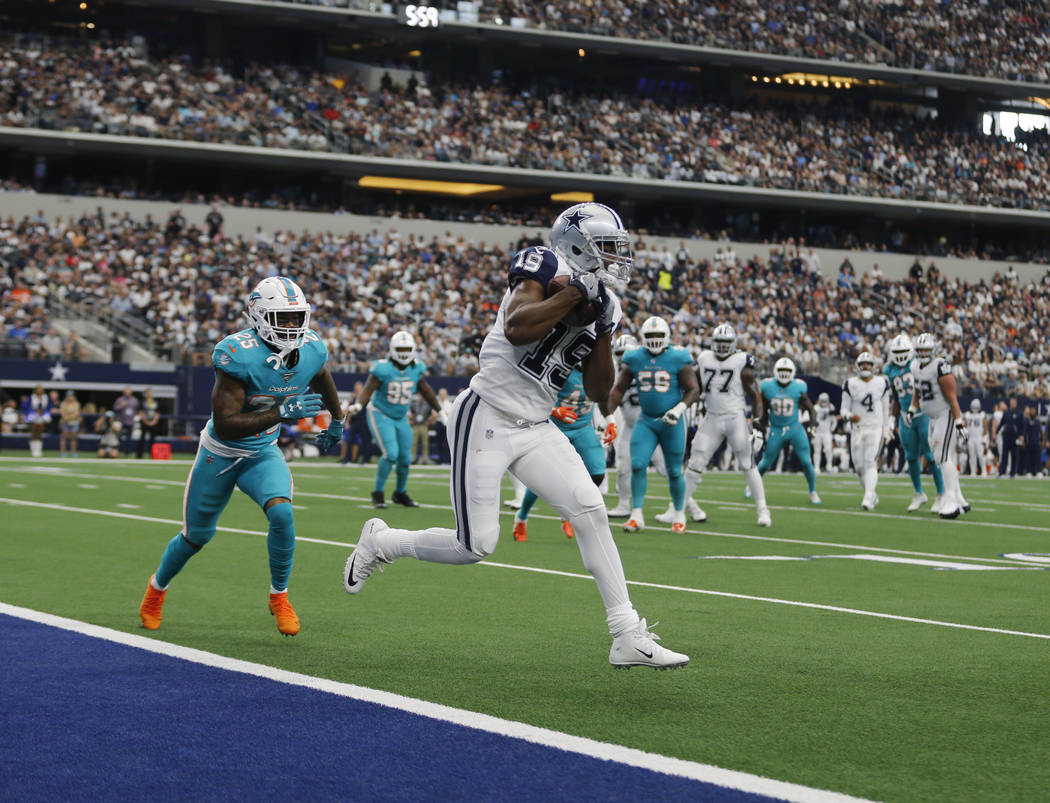 Dallas Cowboys wide receiver Amari Cooper (19) catches a touchdown pass in front of Miami Dolph ...