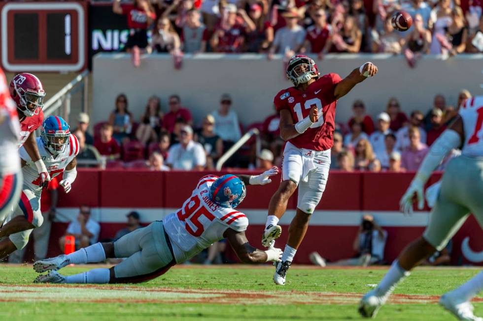 Alabama quarterback Tua Tagovailoa (13) throws under pressure from Mississippi defensive linema ...