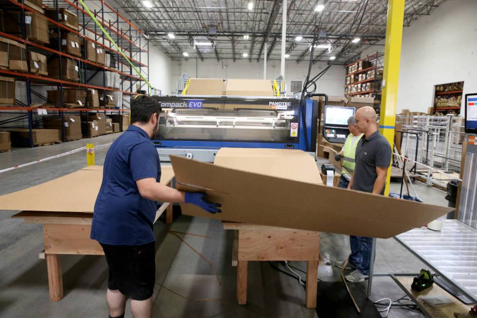 Jose Magdaleno, from left, Marlon Obsuna and Joseph Divino make a custom box after scanning the ...