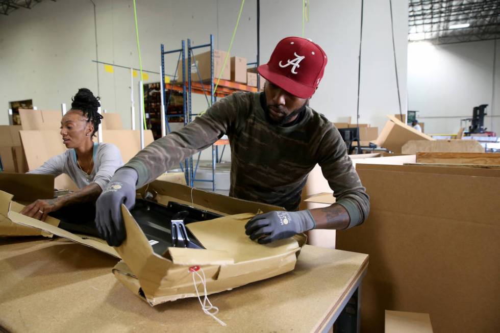 Donald Brown and Brandi Gordon package car parts at the new CarParts.com distribution facility ...