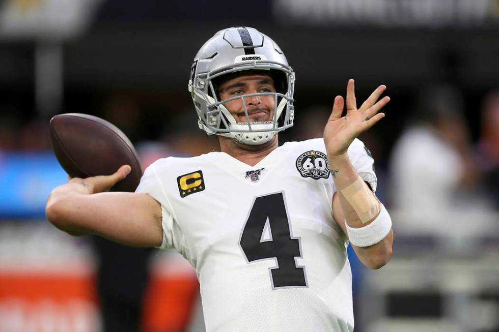 Oakland Raiders quarterback Derek Carr warms up before an NFL football game against the Minneso ...