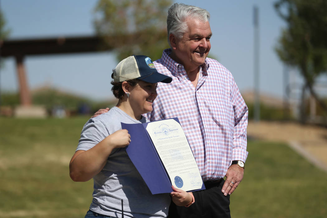 Gov. Steve Sisolak, right, takes a photo with Annette Magnus, executive director for Battles Bo ...