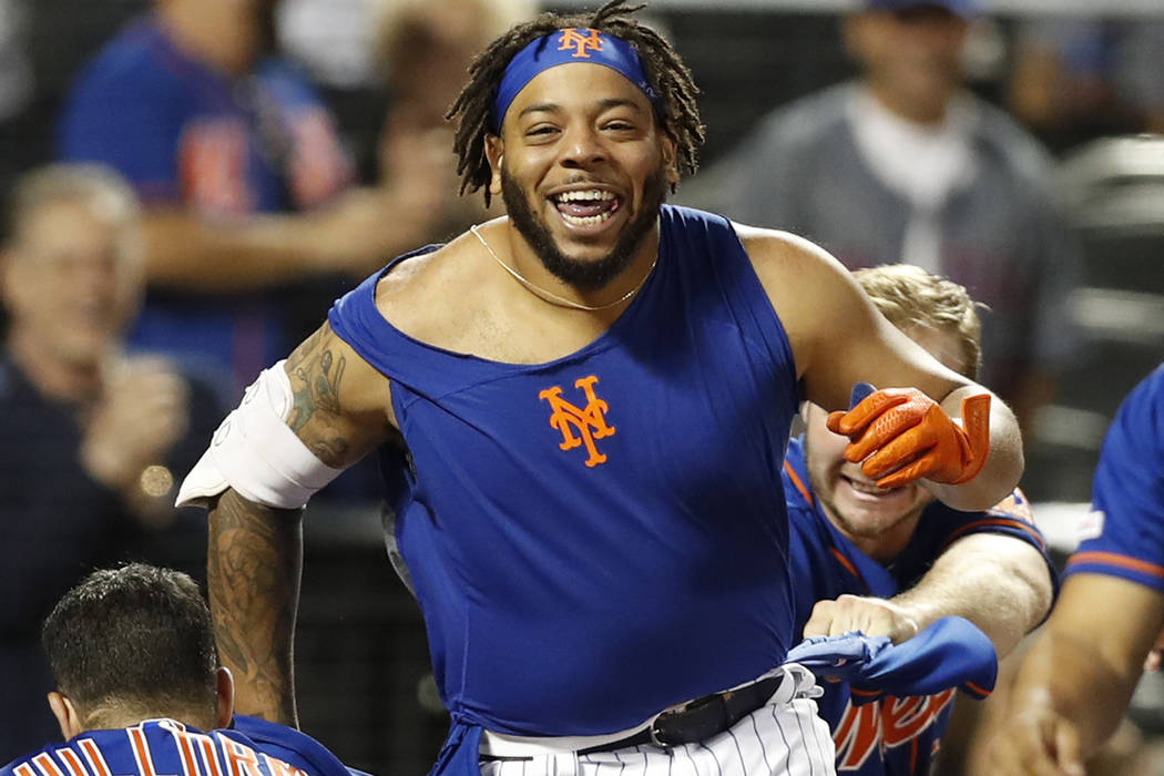 New York Mets shortstop Luis Guillorme (13) and Pete Alonso, right, tear the jersey off teammat ...