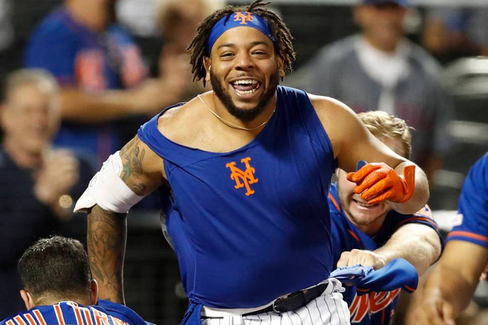 New York Mets shortstop Luis Guillorme (13) and Pete Alonso, right, tear the jersey off teammat ...