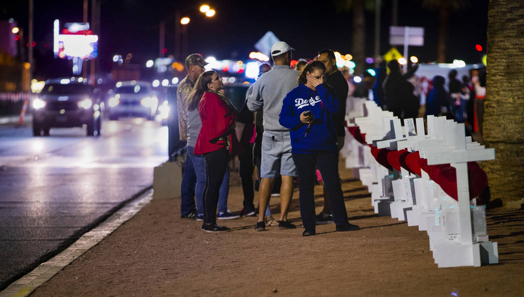 Visitors walk along the line of 58 crosses Greg Zanis placed near the "Welcome to Fabulous Las ...