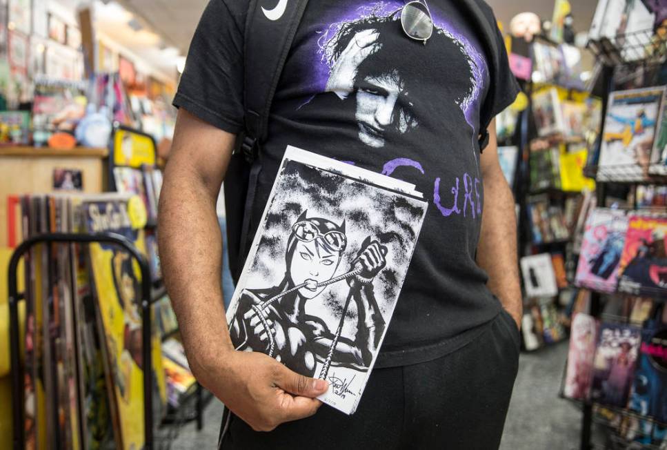 Comic book illustrator Ron Williams holds a sketch of Catwoman during free comic book day at Al ...
