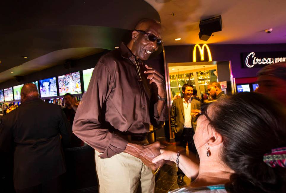 George Bell, who stands 7 feet 8 inches tall, greets onlookers while hanging out at the Longbar ...