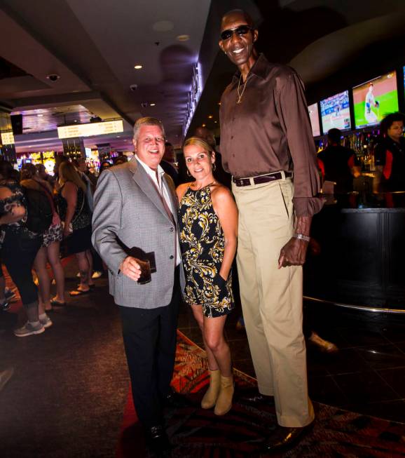 George Bell, who stands 7 feet 8 inches tall, poses for a portrait with Derek Stevens, owner of ...