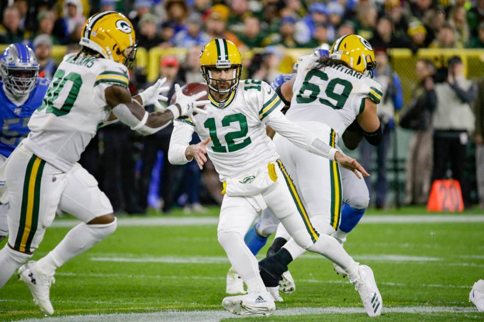 Green Bay Packers quarterback Aaron Rodgers pitches the ball to running back Jamaal Williams (3 ...