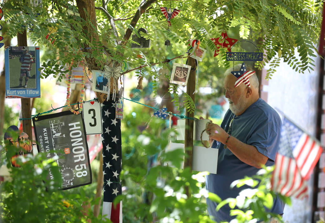 Michael Hyatt, 67, decorates his brother-in-law's tree, Kurt Von Tillow, who was killed during ...