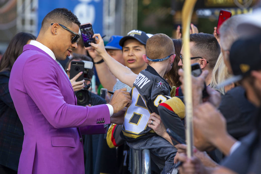 Vegas Golden Knights right wing Ryan Reaves signs an autograph for a fan while walking the gold ...