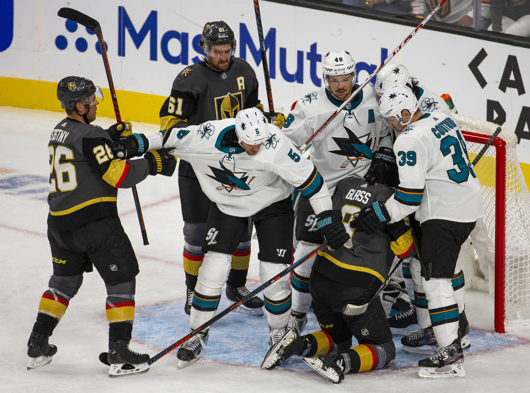 Vegas Golden Knights and San Jose Sharks players fight at the net after a near goal by Vegas Go ...