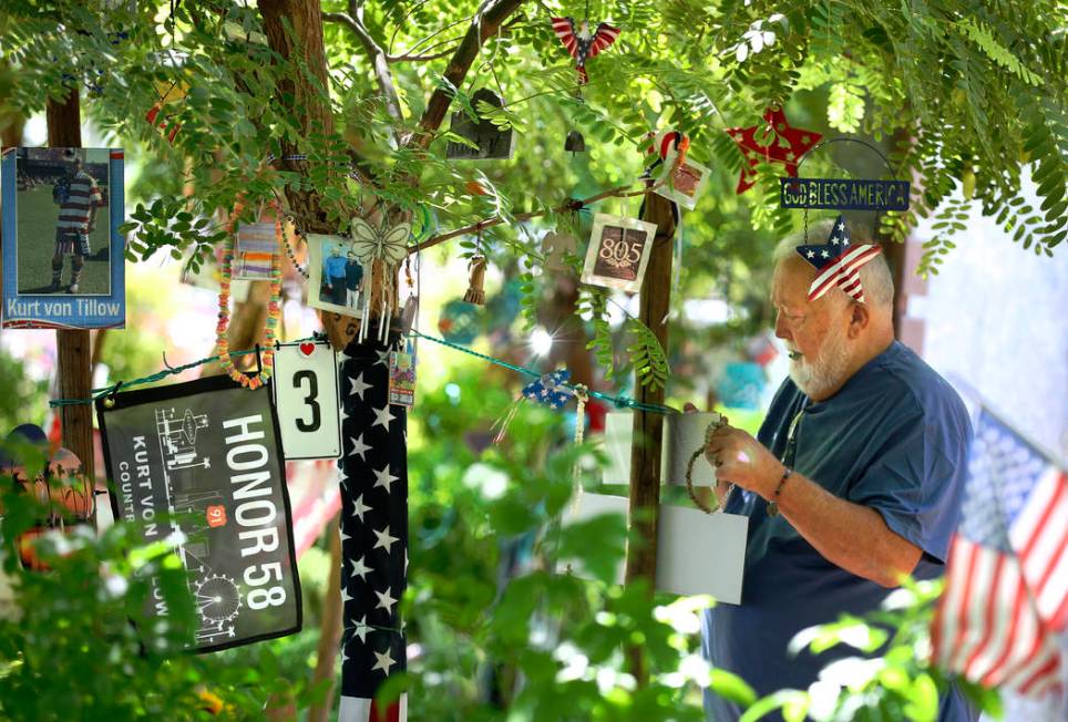Michael Hyatt, 67, decorates his brother-in-law's tree, Kurt Von Tillow, who was killed during ...
