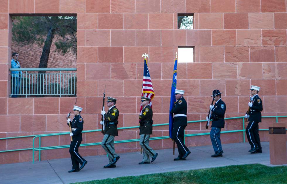 Members of a multi-agency honor guard march to present the colors during a sunrise ceremony at ...