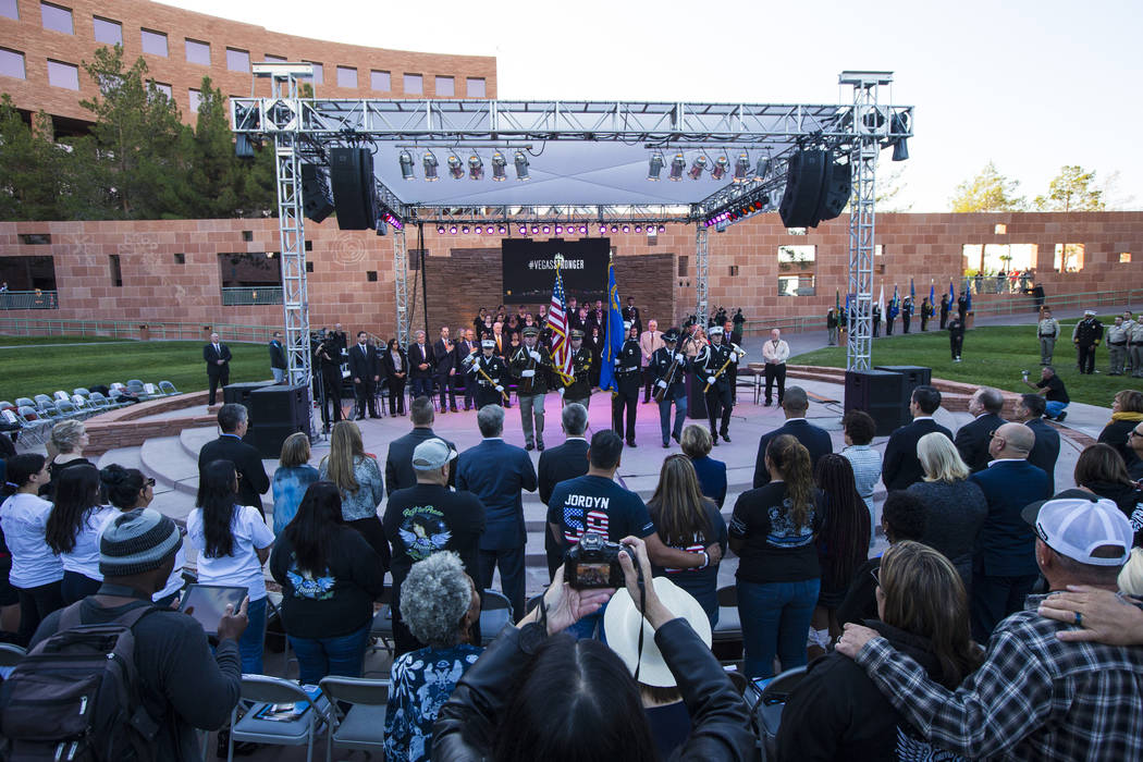 Attendees watch members of a multi-agency honor guard at the end of a sunrise ceremony in remem ...