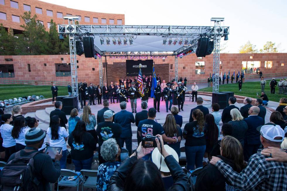 Attendees watch members of a multi-agency honor guard at the end of a sunrise ceremony at the C ...