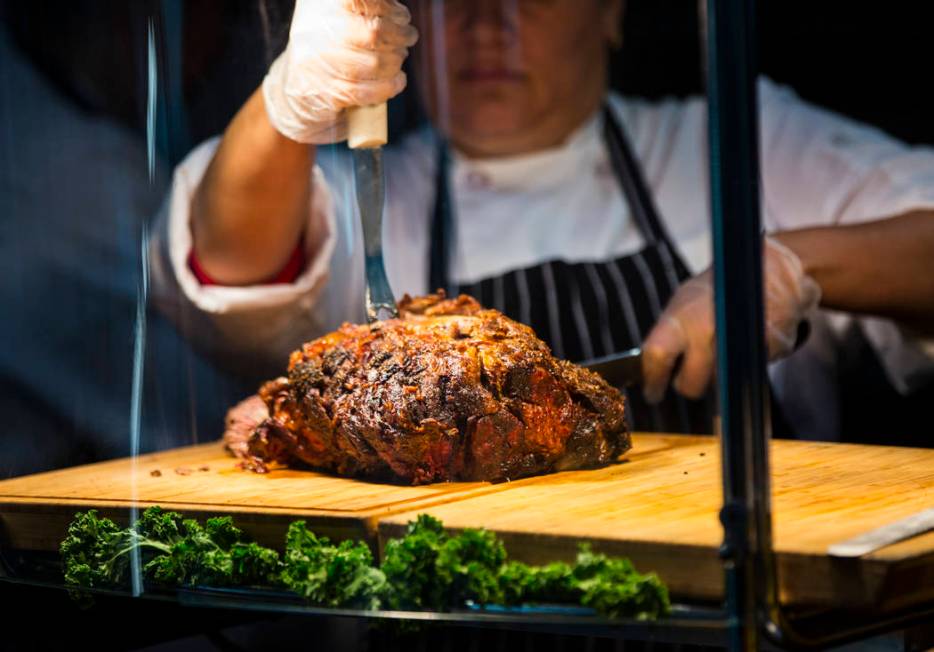 Prime rib is prepared for the herb crusted prime rib sandwich at the Carvery before the start o ...