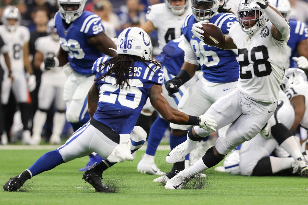 Oakland Raiders running back Josh Jacobs (28) runs past Indianapolis Colts strong safety Clayto ...