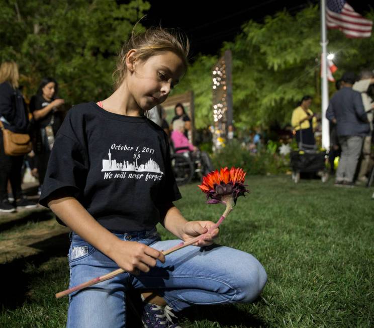 Ella Goldy holds a red sunflower honoring her mother Samantha Olander, who survived the Route 9 ...