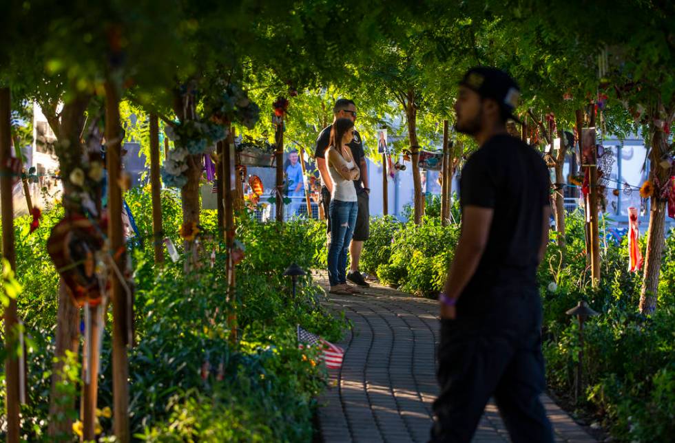 Visitors walk along the path of decorated trees at the Las Vegas Healing Garden on Tuesday, Oct ...