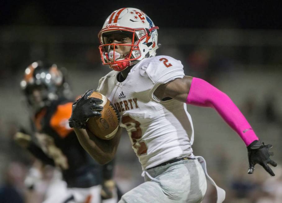 Liberty sophomore wide receiver Germie Bernard (2) breaks down the sideline past a Chaparral de ...