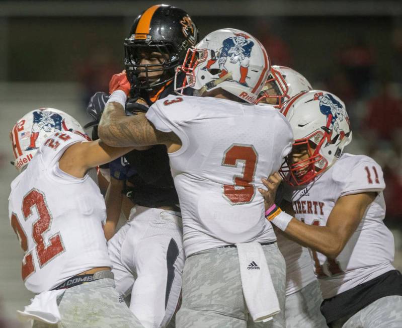 Chaparral senior running back Meshach Hawkins (3) is stacked up by a gang of Liberty defenders ...