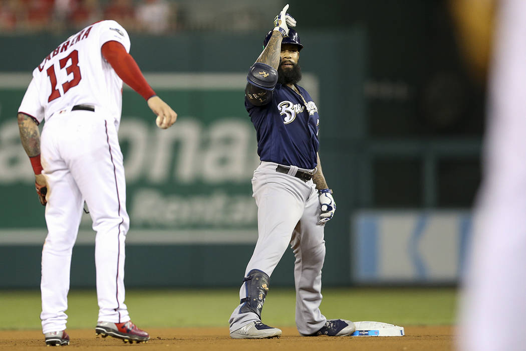 Milwaukee Brewers' Eric Thames, center, gestures to his teammate after hitting a double during ...