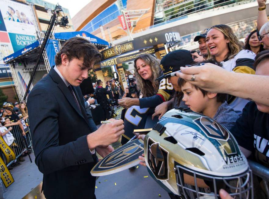Golden Knights' Cody Glass signs autographs on the gold carpet after arriving for the NHL seaso ...