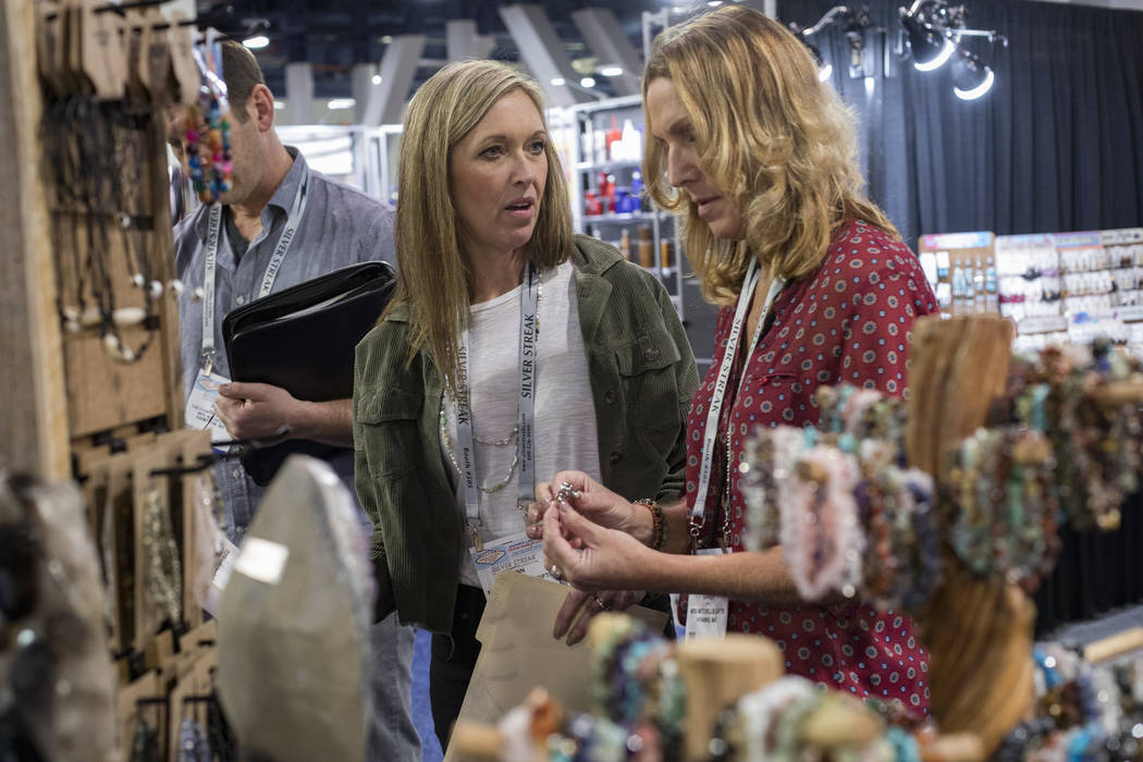 Lynn Mitchell, left, of Cape Cod, looks at gem stones and jewelry for sale next to colleague Ka ...