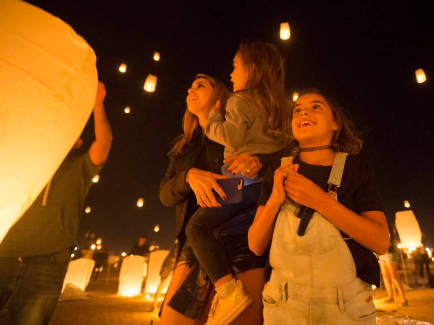 Jessica, June and Jade Laos watch their lanterns fly into the sky during the RiSE Lantern Festi ...