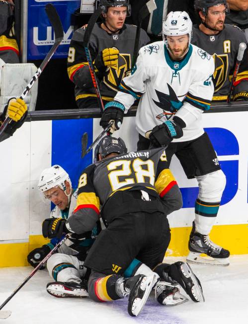 Vegas Golden Knights left wing William Carrier (28) takes down San Jose Sharks center Dylan Gam ...