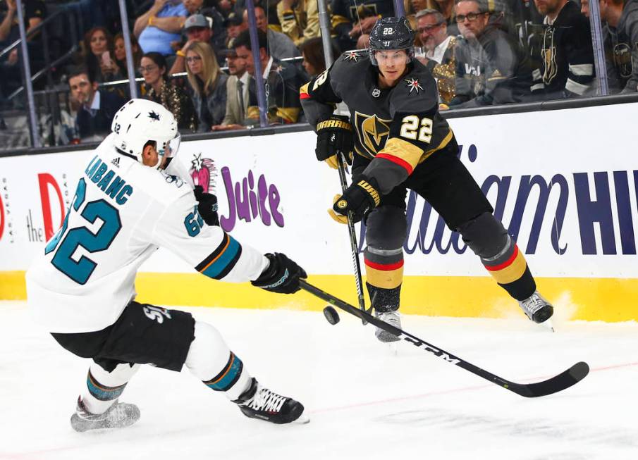 Golden Knights' Nick Holden (22) sends the puck past San Jose Sharks' Kevin Labanc (62) during ...