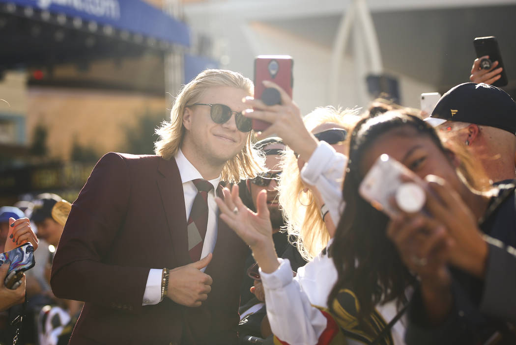 Golden Knights' William Karlsson takes pictures with fans on the gold carpet after arriving for ...