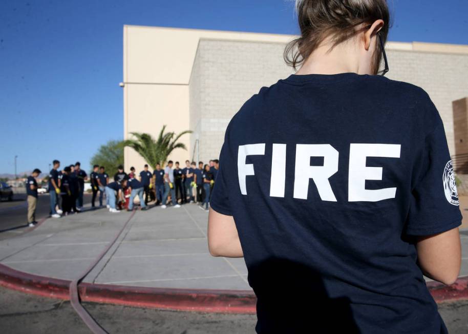 Bonanza High School Fire Science Academy junior Dorothy Elliott attaches a nozzle to a fire hos ...