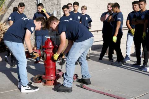 Bonanza High School Fire Science Academy juniors Carlos Olguin, left, and Noah Nason prepare to ...