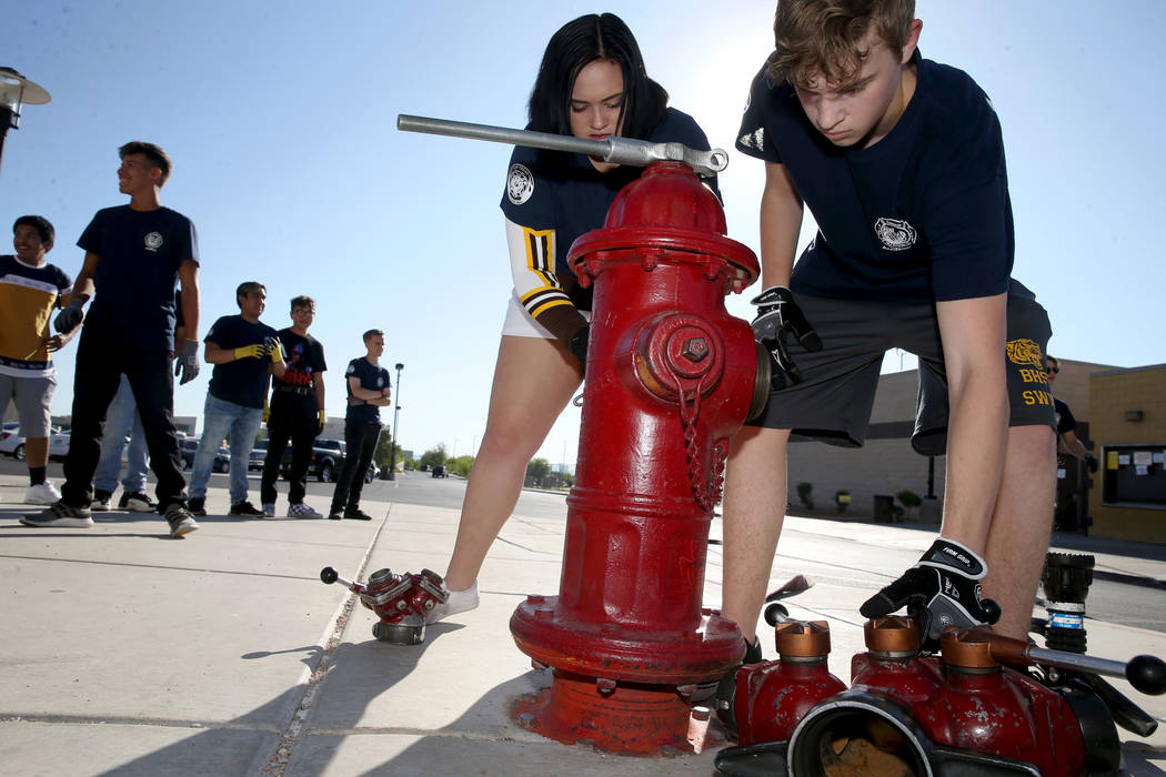 Bonanza High School Fire Science Academy seniors Madi Hornbrook and Charlie Stromoski hook a ho ...