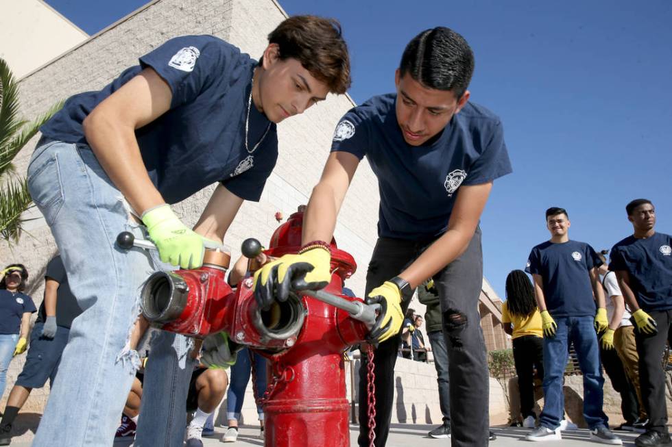 Bonanza High School Fire Science Academy seniors Jerry Galaviz, left, and Angel Corona hook a h ...