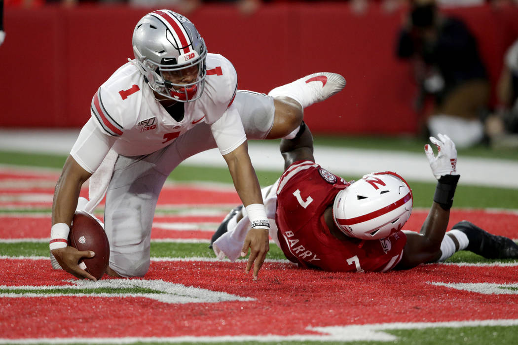 Ohio State quarterback Justin Fields (1) scores a touchdown next to Nebraska linebacker Mohamed ...