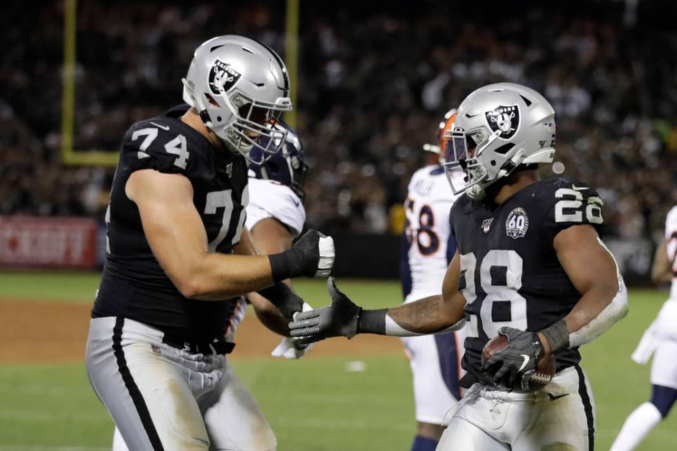 Oakland Raiders running back Josh Jacobs, right, is greeted by offensive tackle Kolton Miller ( ...