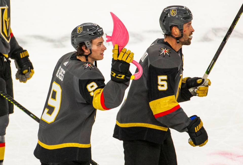 Vegas Golden Knights center Cody Glass (9) receives a pink flamingo and skates with teammate de ...