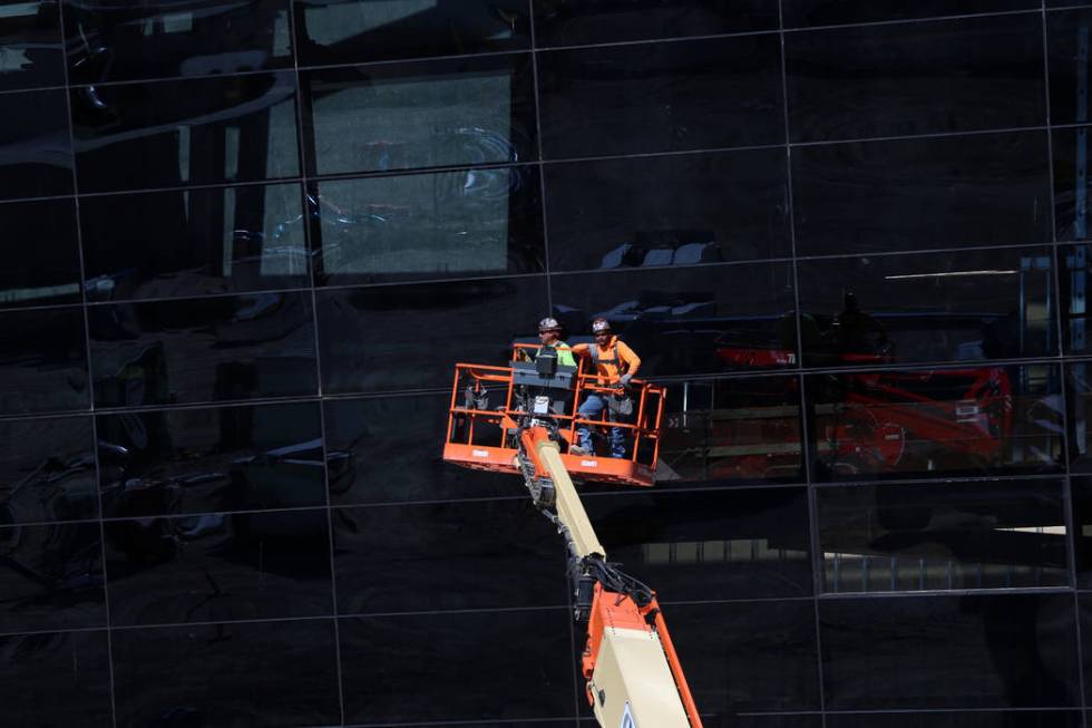 Workers go up on a construction lift at the Raiders Allegiant Stadium in Las Vegas, Thursday, O ...