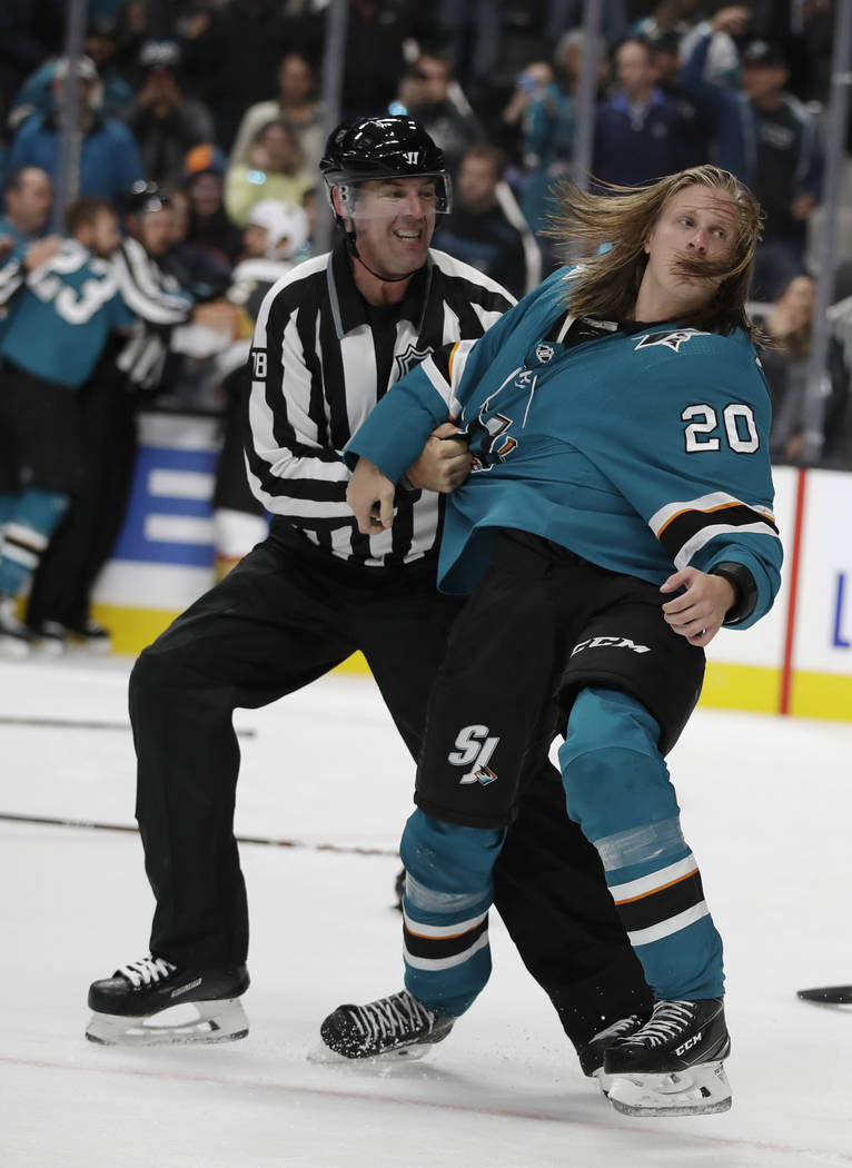 Linesman Brian Mach, left, restrains San Jose Sharks' Marcus Sorensen during a fight in the thi ...