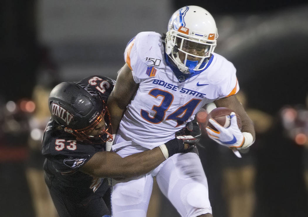 Boise State Broncos running back Robert Mahone (34) tries to break free of UNLV Rebels lineback ...