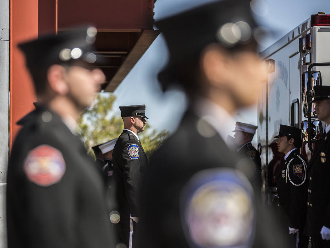 Henderson Fire and Police Department personnel wait to escort the cremated remains of Henderson ...